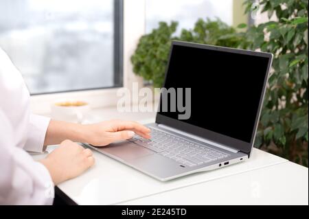 mocup laptop. Hand using laptop with blank black screen at home office. woman using and typing on laptop computer with blank black desktop screen Stock Photo