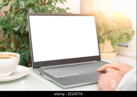 businesswoman using mock up laptop with notebook and coffee cup on office desk. business woman using and typing on laptop with blank white screen and Stock Photo