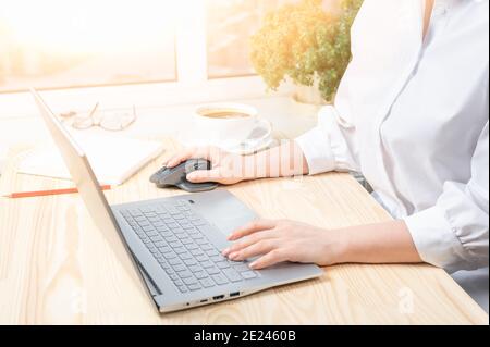 Freelance woman's hands on the keyboard laptop computer in a cafe, girl using laptop typing, Businesswoman typing on computer keyboard in sunny office Stock Photo