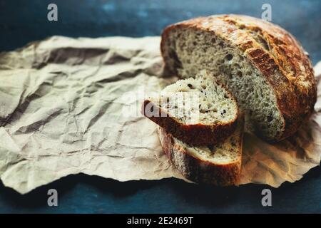 It is a loaf of fresh crusty bread with cereals on sourdough. Yeast-free homemade cakes close-up. Stock Photo