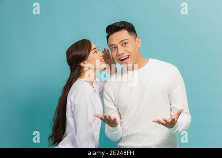 Beautiful woman whispering to boyfriend's ear