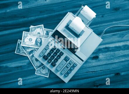 Old fashioned calculator and dollars on a desk Stock Photo