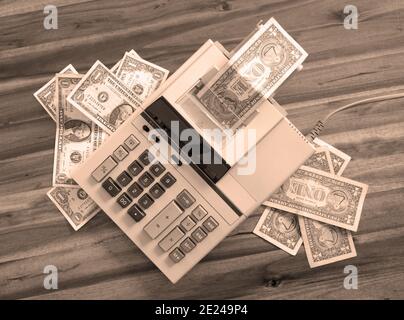 Old fashioned calculator and dollars on a desk Stock Photo