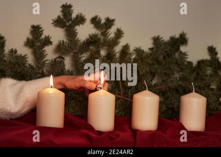 Hand lighting Advent candle Stock Photo