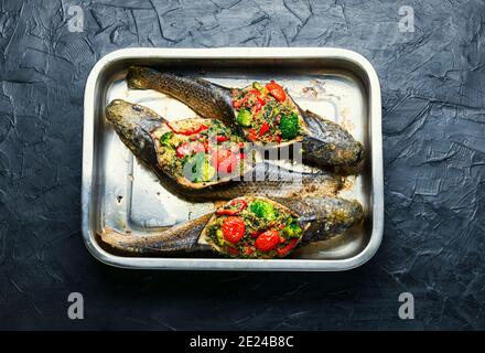 Roasted fish stuffed with broccoli and quinoa.Baked fish with vegetables in tray Stock Photo