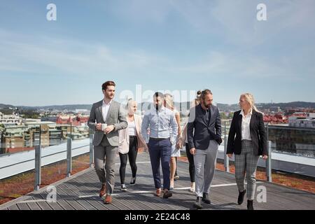 Coworkers walking on terrace Stock Photo