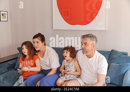 Family watching TV on sofa Stock Photo