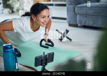 Beautiful smiling woman performing a strength exercise Stock Photo