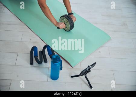 Female hands rolling the ab wheel forward Stock Photo