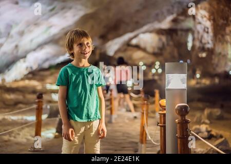 Boy tourist in Hang Sung Sot Grotto Cave of Surprises, Halong Bay, Vietnam. Traveling with children concept. Tourism after coronavirus Stock Photo