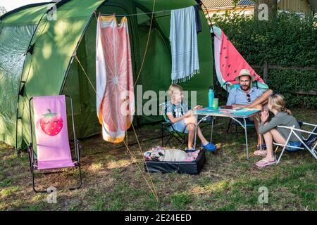 Father with children in front of tent Stock Photo