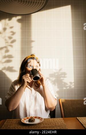 Pregnant woman drinking coffee in kitchen Stock Photo