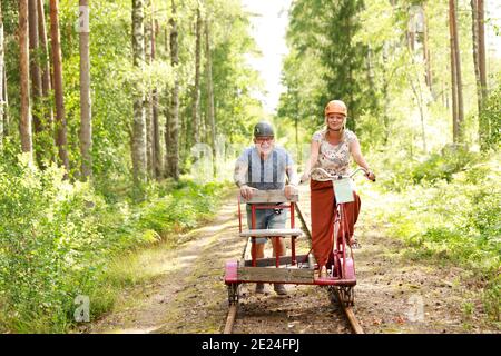Couple riding handcar Stock Photo