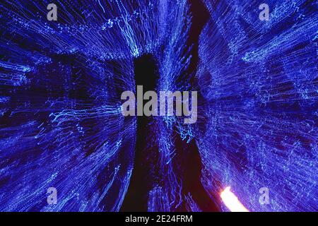 Rays of abstract lights on a black background, in blue color, as well as effects of movement, vibration and transformation. Stock Photo