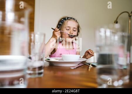 Girl eating at table Stock Photo