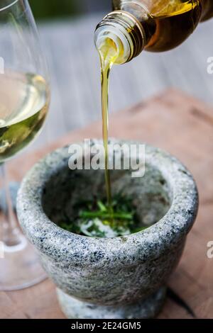 Pouring olive oil into mortar Stock Photo