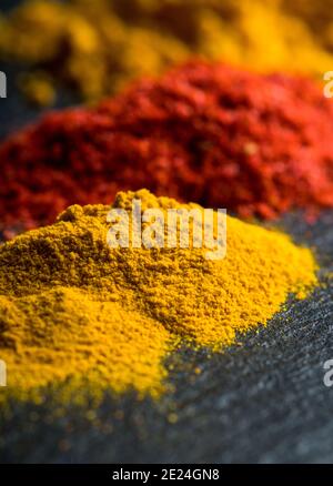Bright and colorful spices on the black stone background. Different spices and herbs for background. Stock Photo