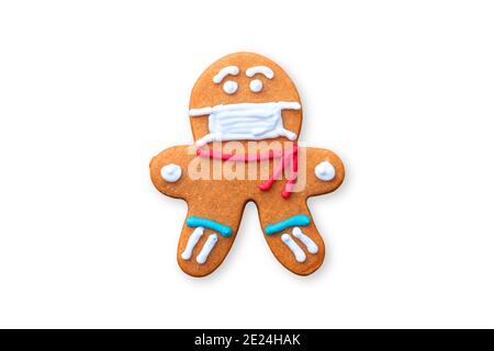 Classic gingerbread cookies man with a medical mask isolated on white background. A gingerbread man cookie in the shape of a man with colored icing. Stock Photo