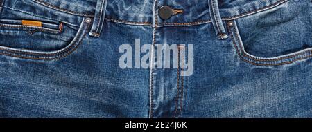 Front pockets, zipper, and its button of dark blue jeans. Close up shot. Clothing concept. Stock Photo