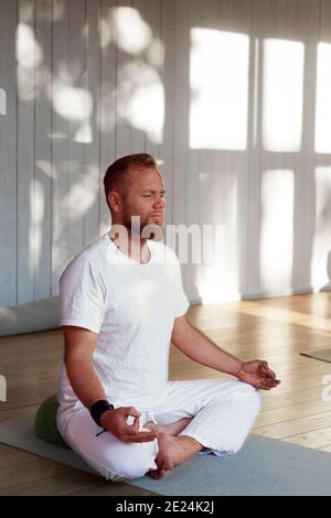 Man practicing yoga in studio Stock Photo