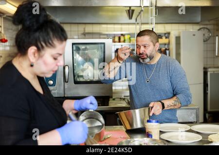 Man and woman preparing food in restaurant kitchen Stock Photo