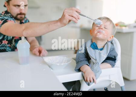 Father feeding toddler son Stock Photo