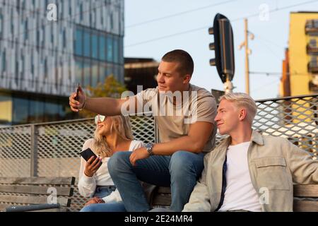 Friends on bench taking selfie Stock Photo