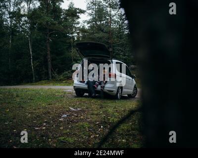 Mother and toddler sitting in open car Stock Photo