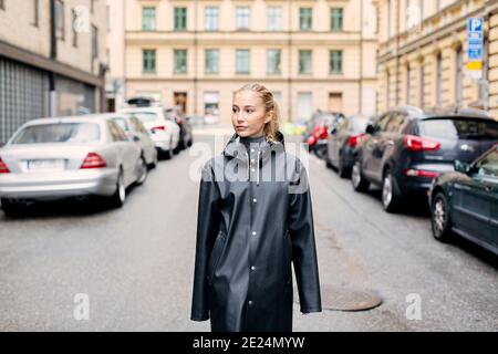 Young woman walking along city street Stock Photo