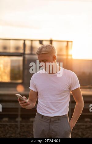Smiling young man holding cell phone Stock Photo