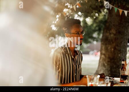Man sitting at table in garden Stock Photo