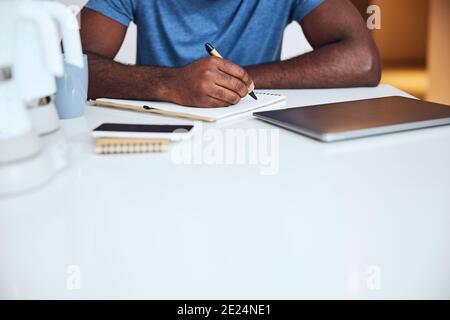 Adult man using a pen for writing in a notepad Stock Photo