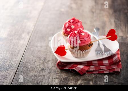Cupcakes decorated with sugar hearts for Valentine's Day on wooden table Stock Photo