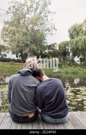 Rear view of two teenage boys sitting together Stock Photo