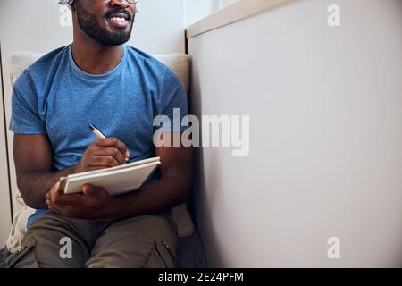 Freelancer lying on a sofa with a notebook Stock Photo
