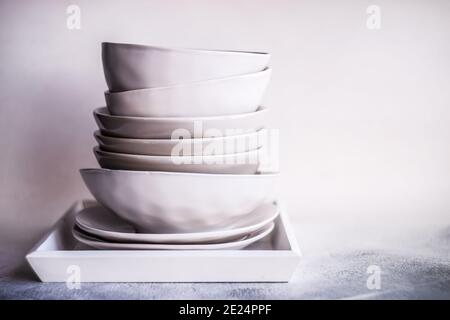 Stack of minimalist bowls and plates on a tray Stock Photo