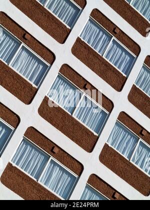 Close up view of windows with curtains on a concrete tower block. Stock Photo