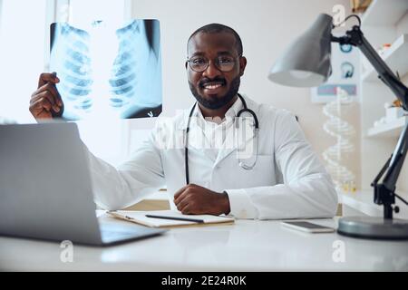 Satisfied therapeutist is showing an x-ray film Stock Photo