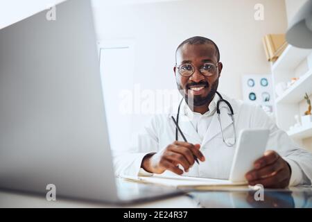 Multiethnic medical practitioner finding information in a cellphone Stock Photo