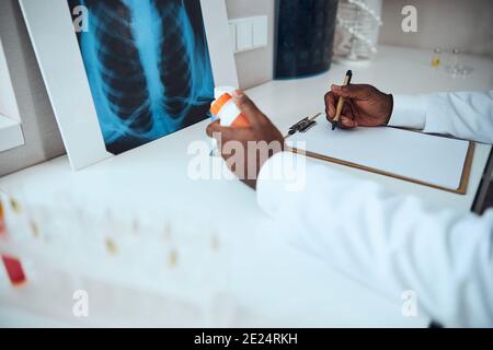 Male in front of a radiograph taking notes about medicine Stock Photo