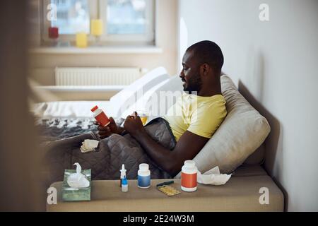 Afro-American person having a bed rest during illness Stock Photo
