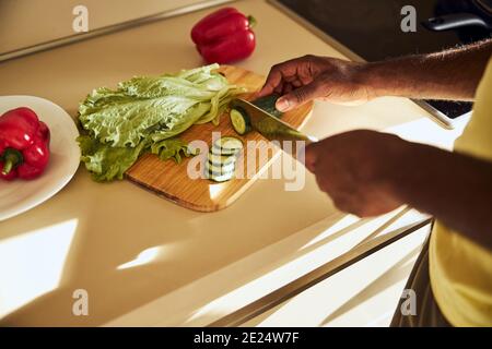 Adult man making a cut to a green vegetable Stock Photo