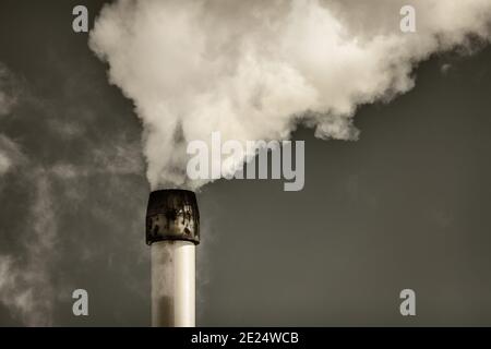 Retro styled image of air pollution from a factory pipe Stock Photo