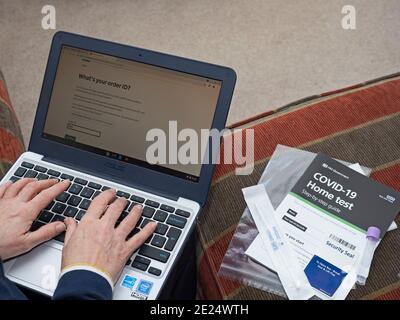 Middle aged woman (Dr Jayne Smith) logging on to UK Government website to register using Covid-19 home testing kit, Holt, Norfolk, January 2021 Stock Photo