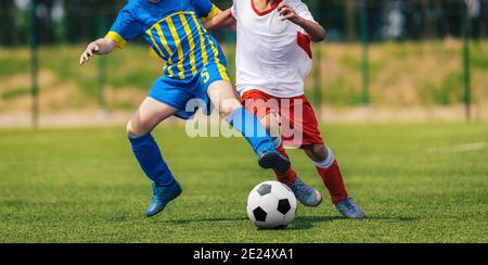 Two Soccer Boys Kicking Ball in Opposite Teams. Young Football Players Running in Duel and Playing Soccer Tournament Match. Sports Competition for You Stock Photo