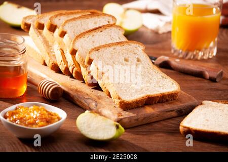 Slices of loaf bread for breakfast with jam and juice Stock Photo