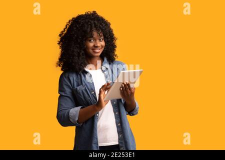 Cheerful beautiful black woman using digital tablet Stock Photo