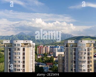 Cityview with modern high rise buildings,  background the mountains of Alatau and Ala Artscha National Park The capital Bishkek located in the foothil Stock Photo