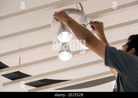 Electrical engineers are installing ceiling lamps in the hallway. Stock Photo