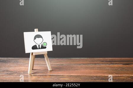 Easel with a symbol of hiring new employees. Help wanted. Recruiting and HR management. Hiring workers, staffing. Headhunters and Human Resources. Sea Stock Photo